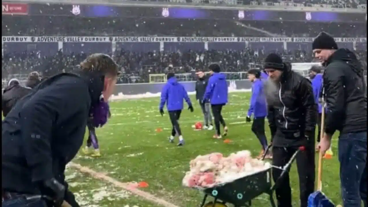 Tifozët belg pastrojnë borën me duar për tu mbajtur ndeshja